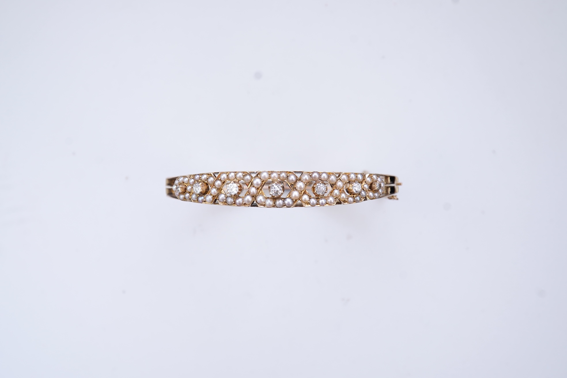 An Edwardian seed pearl and diamond bangle, early 20th century